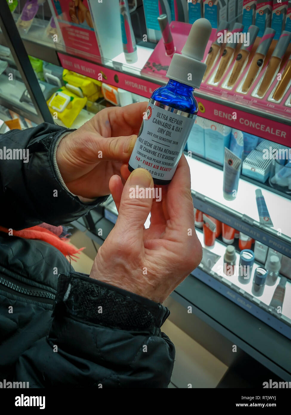 A woman holds a bottle of First Aid Beauty brand "Ultra Repair Cannabis and Oat Dry Oil" in a health and beauty supply store in New York on Sunday, February 24, 2019. The produce contains Cannabis Sativa Seed Oil from hemp and is part of the growing trend of infusing products with hemp and CBD related ingredients. (Â© Richard B. Levine) Stock Photo