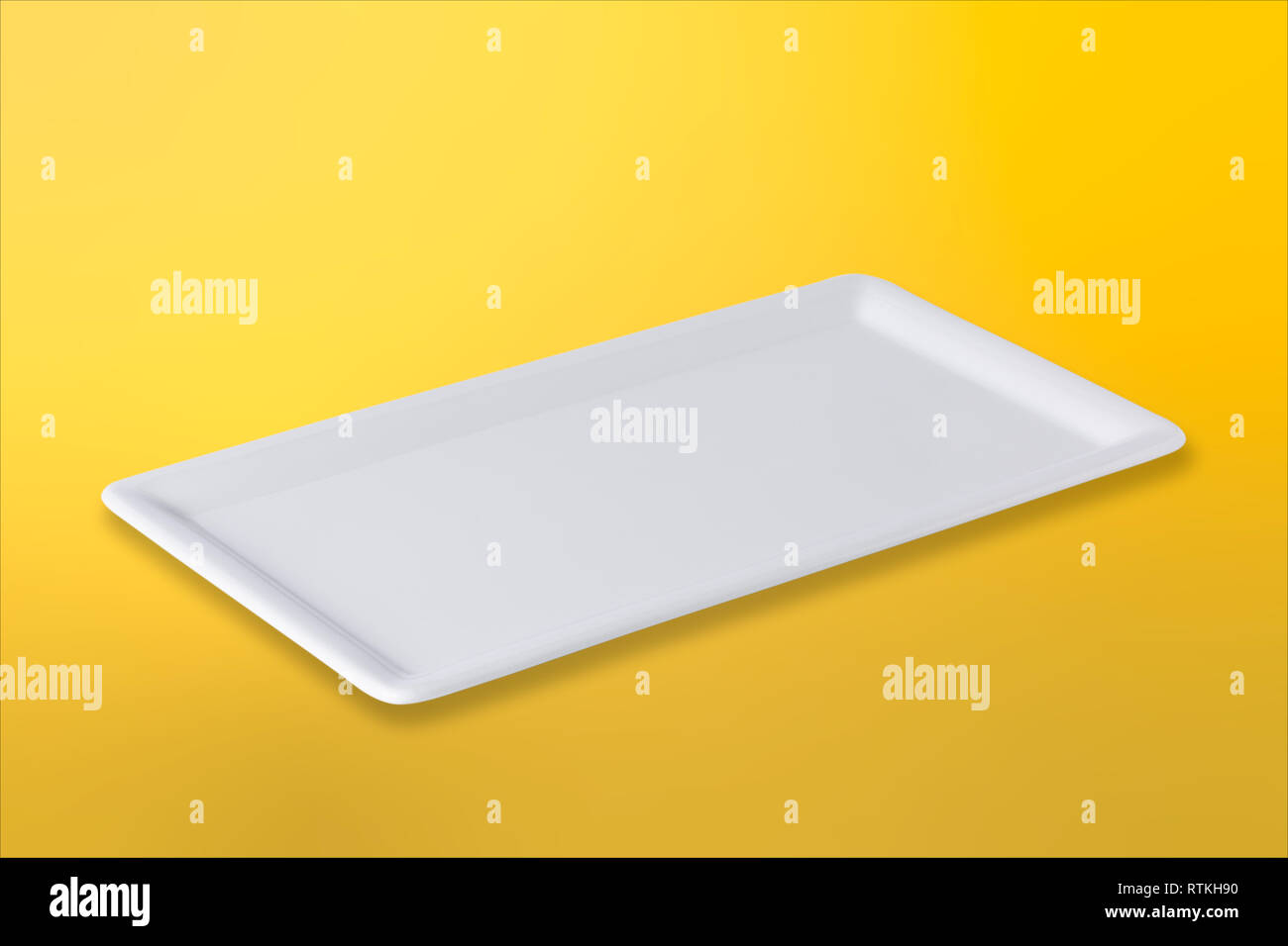 Empty white cornered plate on gradient yellow orange background, front view, oblique position Stock Photo