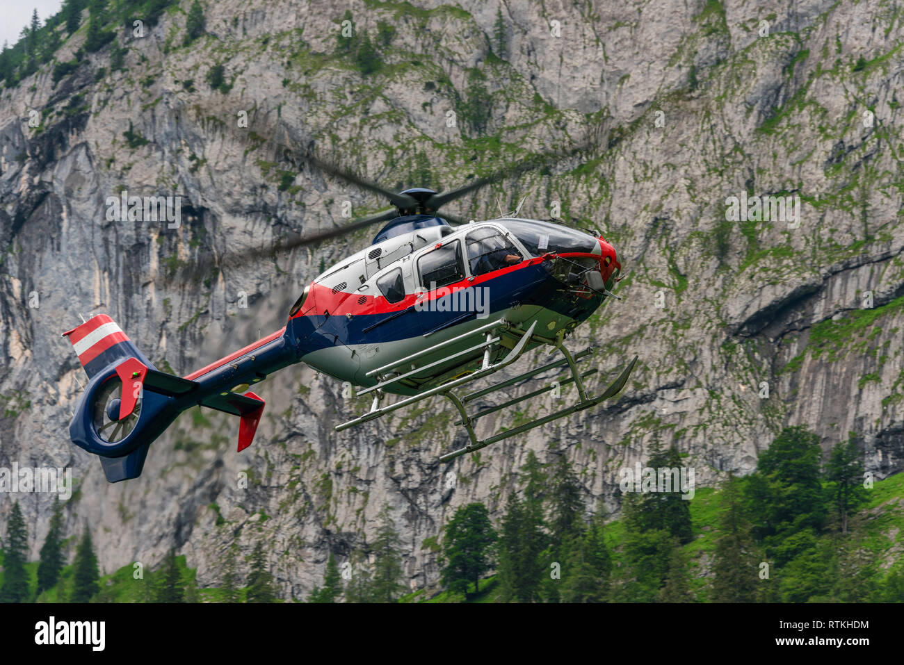 Mountain Rescue Helicopter landing at a mountain lake in the Dachstein Massif (Hoher Dachstein) Due an emercency of injured Alpinists Stock Photo