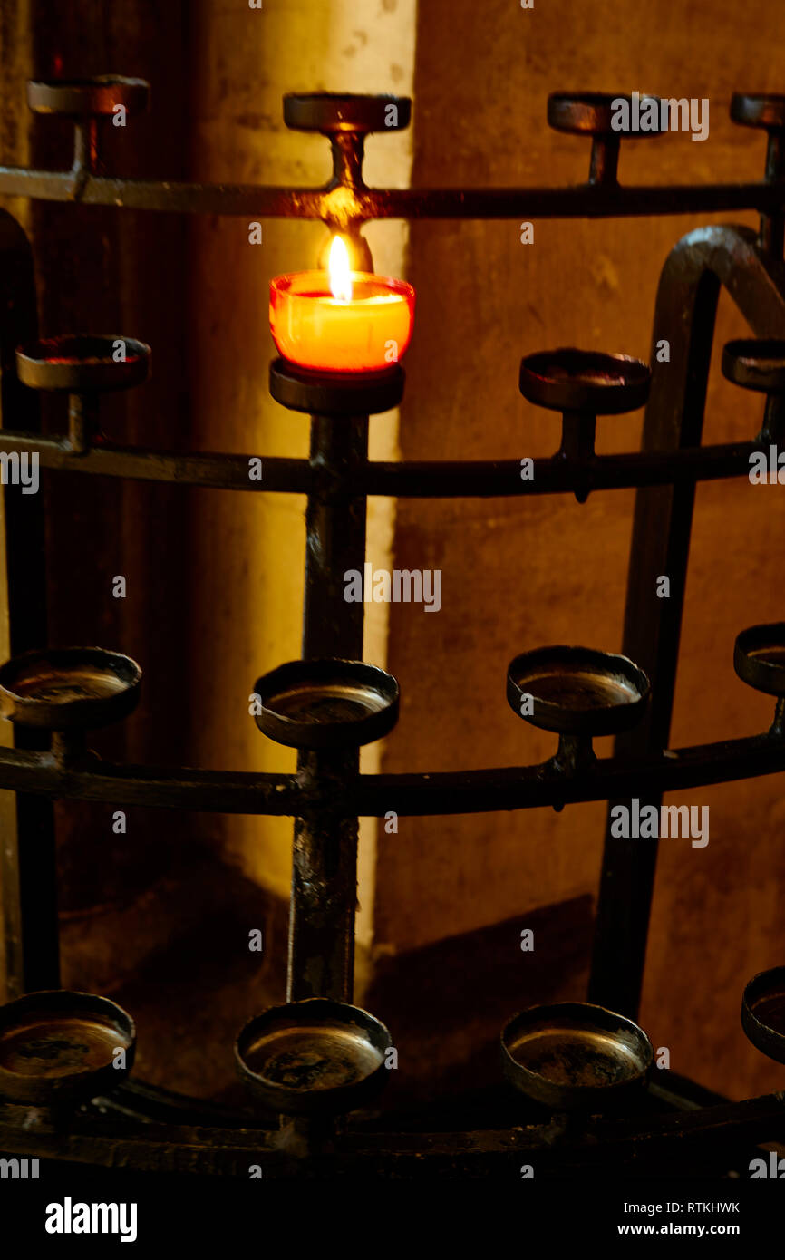 White votive candle on stand in church, Kent, England, United Kingdom