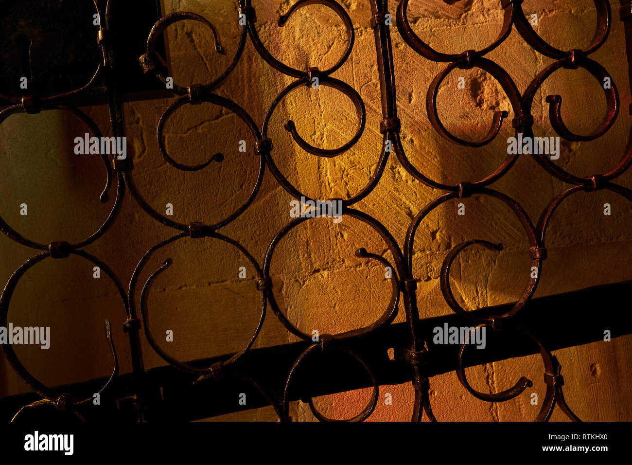 Abstract metal swirl patterns against warm stone background Stock Photo