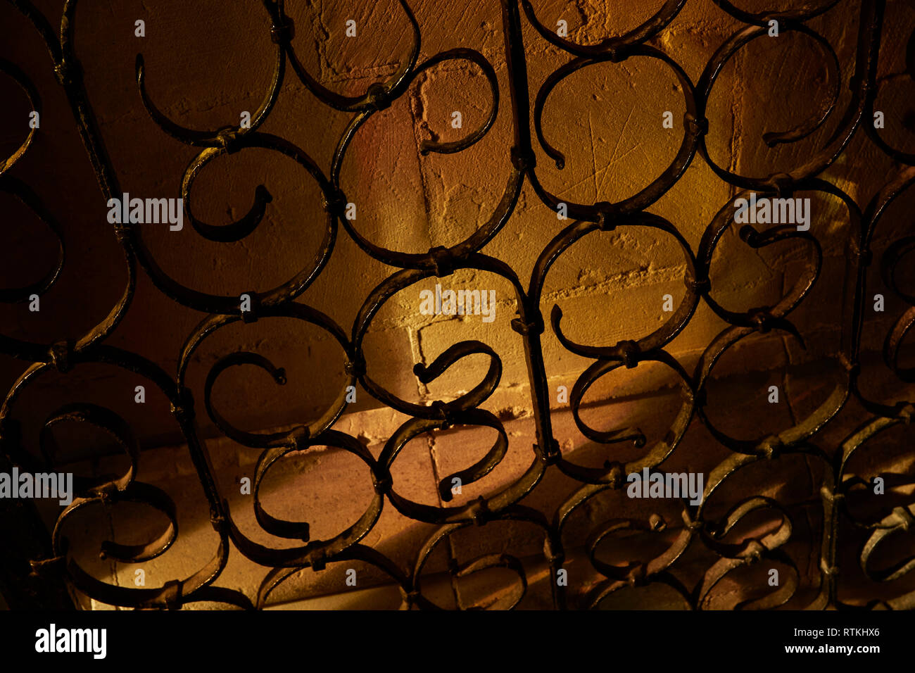 Abstract metal swirl patterns against warm stone background Stock Photo