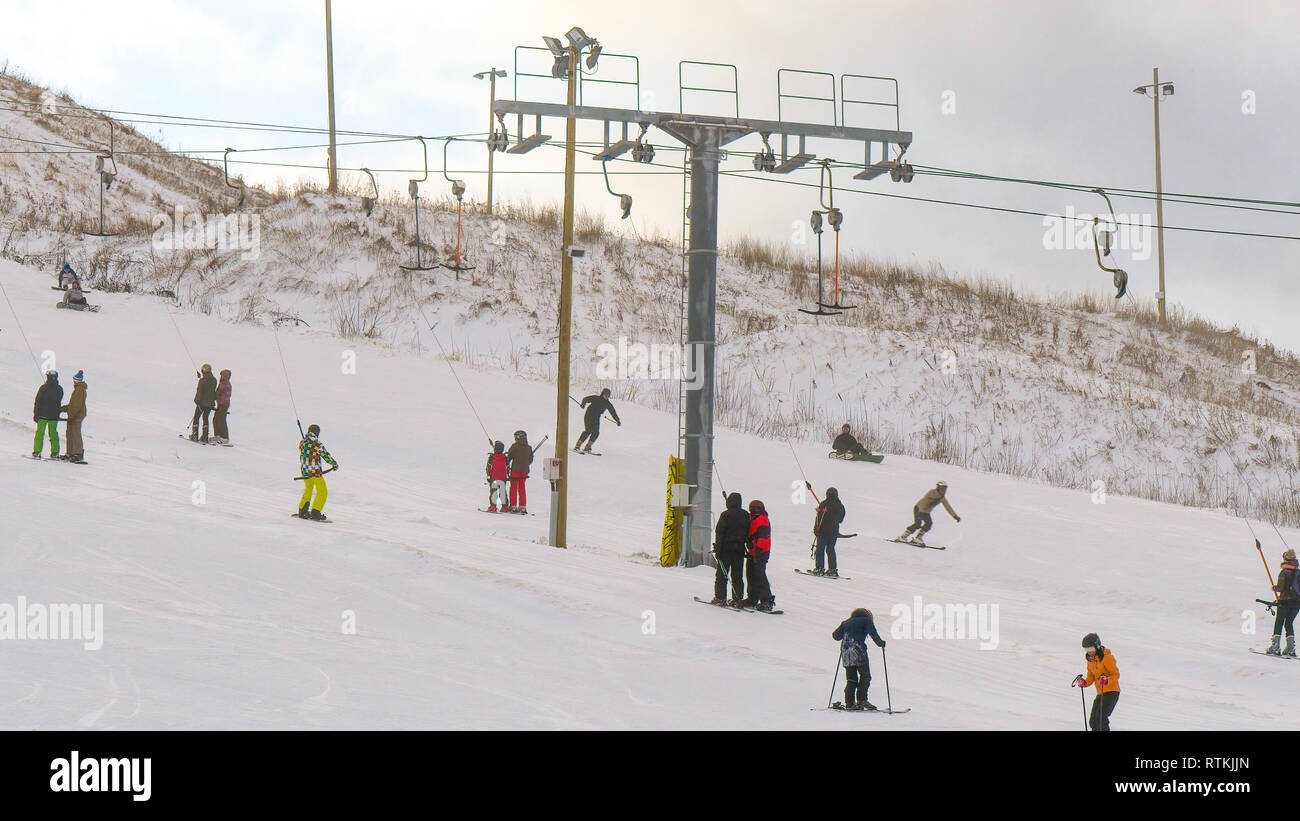 Some people are riding the Finland Skandinavian ski lift on the resort to reach the top of the ski resort Stock Photo