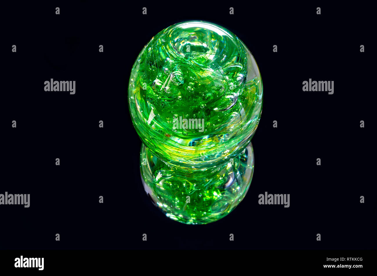vibrant green glass sphere and reflection isolated against black Stock Photo