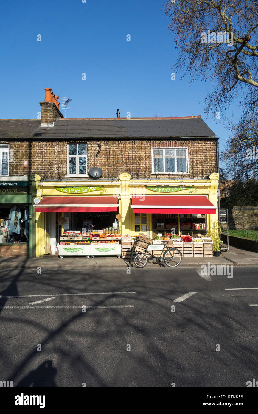 Two Peas In a Pod - Sunlit greengrocers corner shop in London, UK Stock Photo