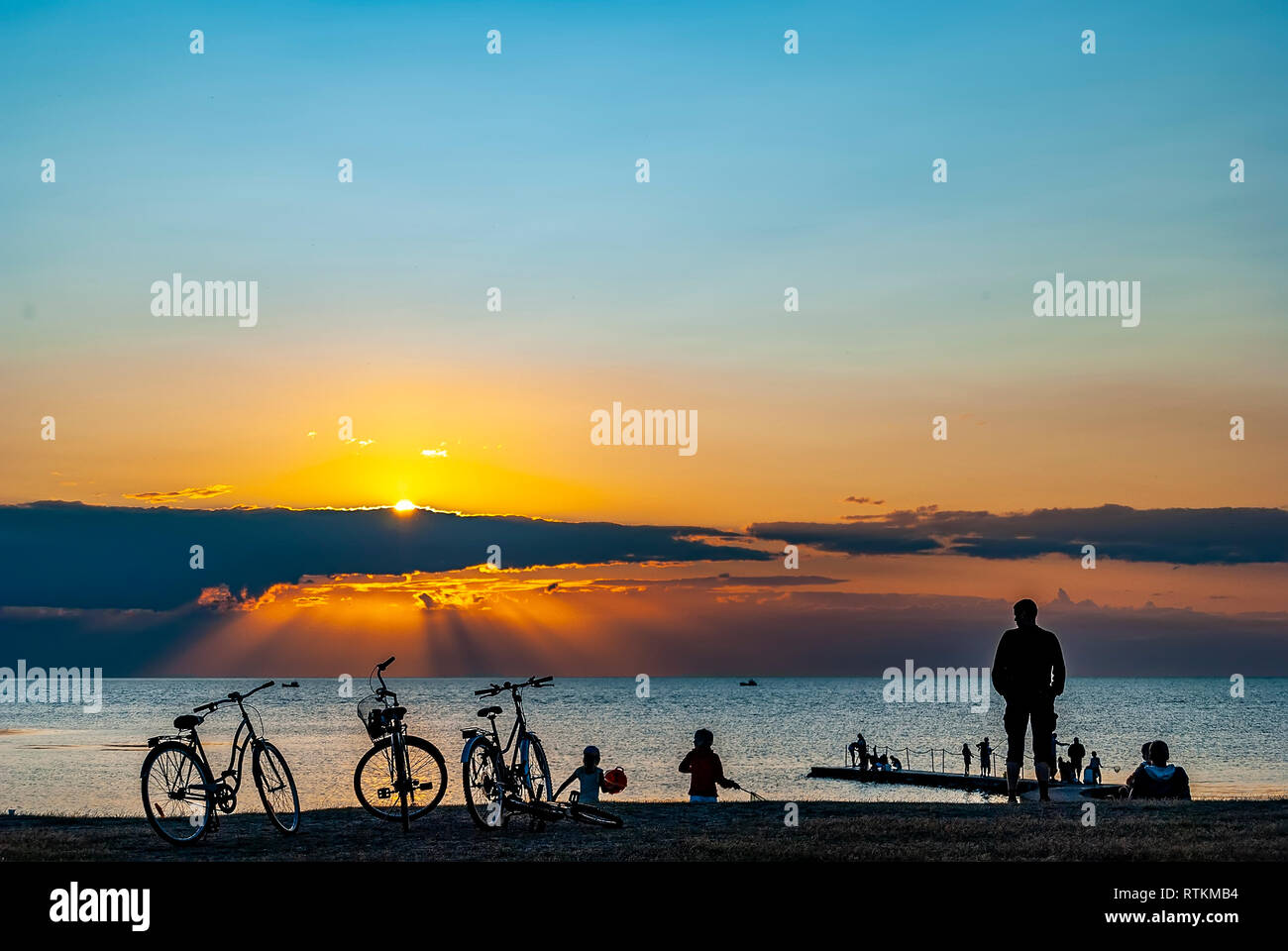 A group of people gather to watch a spectacular sunset at Torekov in Sweden. Stock Photo