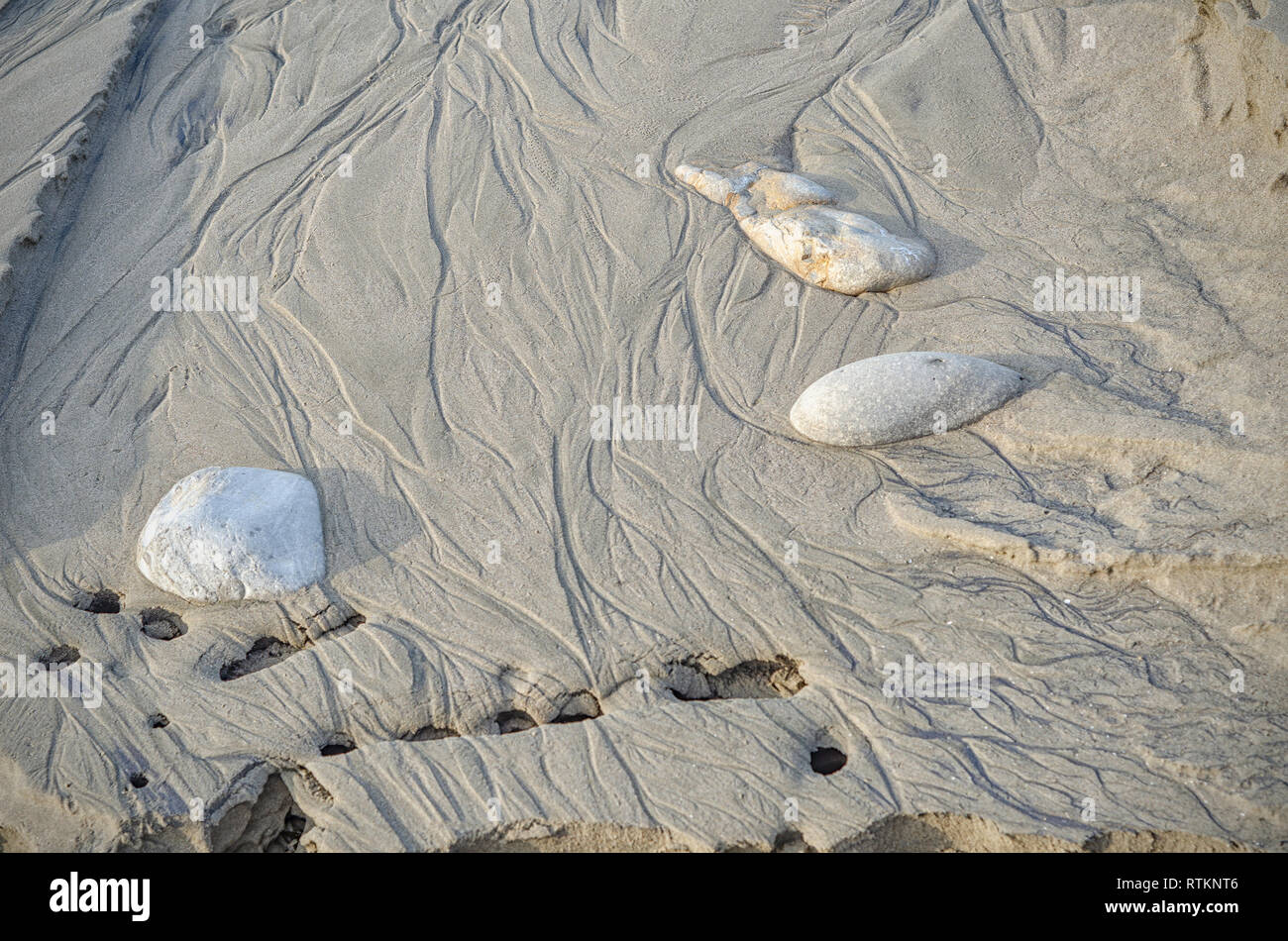 Rocks on the sandy beach are revealed as the tide recedes, Refugio State Beach, Goleta, CA. Stock Photo