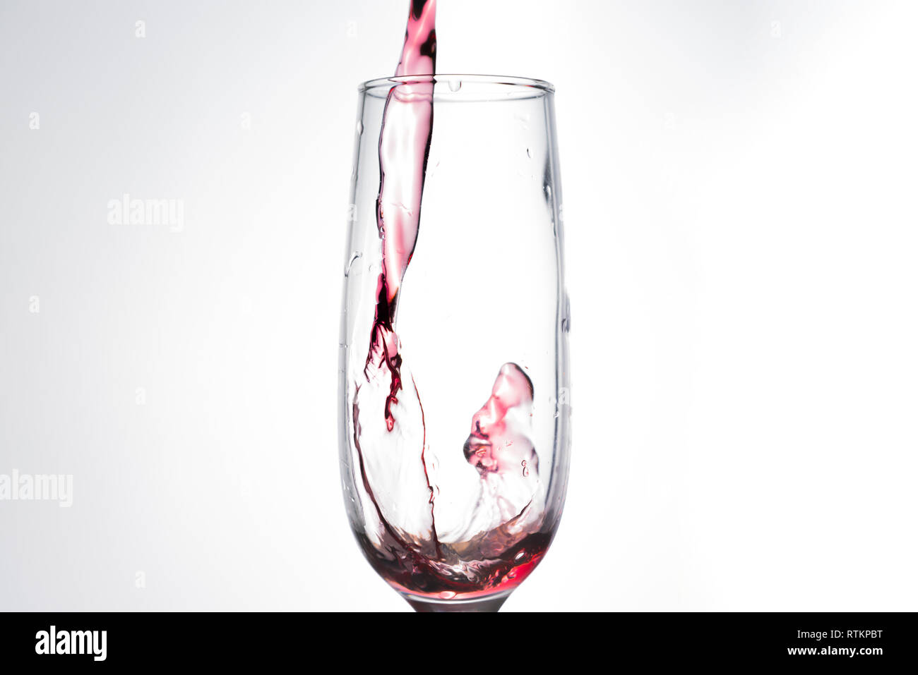Pouring Red Wine Isolated On White Narrow And Tall Wine Glass