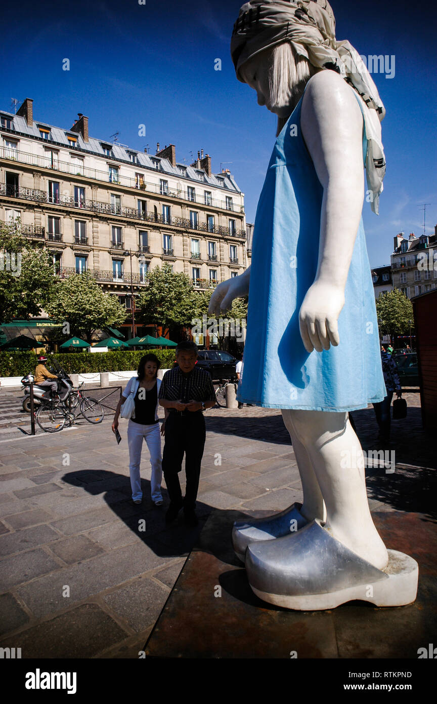 PARIS ART -  FRENCH ART -  COLLECTIF 6 BIS - ARTISTES PARCOURS ST GERMAIN DES PRÉS SIXIÈME ÉDITION - A COUPLE OF TOURIST IN  THE SHADOW OF A MASSIVE CHILD SCULPTURE  IN ST GERMAIN DES PRES  - PARIS STREET ART - CONTEMPORARY ART IN PARIS - STREET ART EXHIBITION IN PARIS - PARIS ART ARCHIVE - ARCHIVE COLOUR © Frédéric BEAUMONT Stock Photo