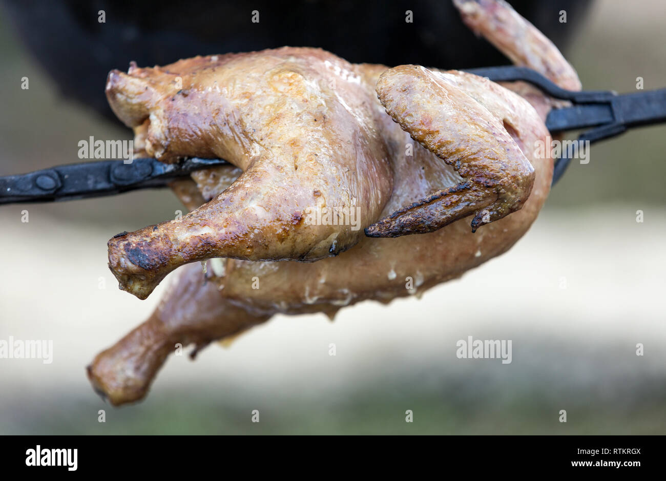 Whole chicken being roasted on an open fire Stock Photo Alamy