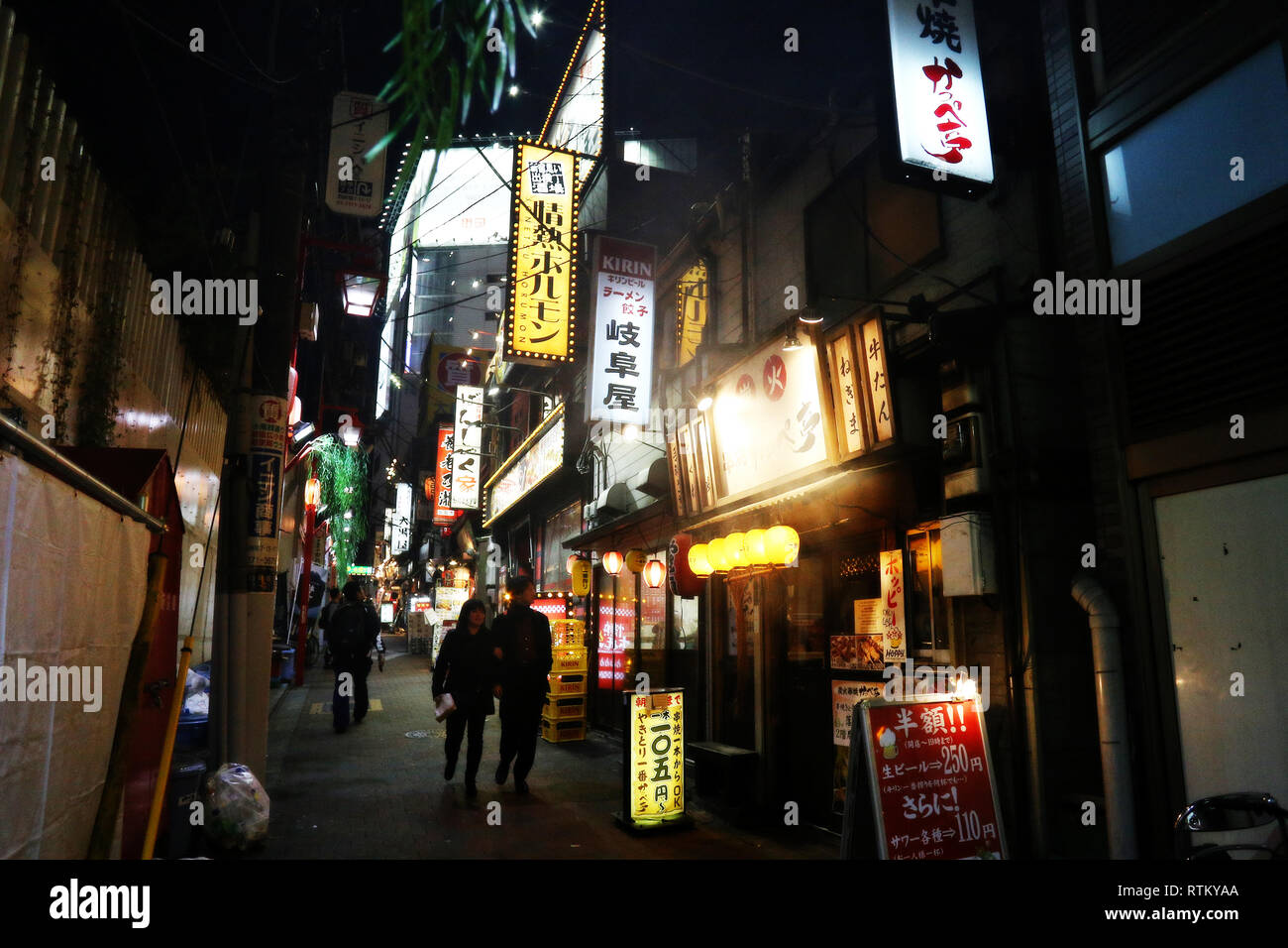 Shinjuku, Tokyo - December 16, 2016: Unidentified couple walking through a Shinjuku ward alley in Tokyo, Japan Stock Photo