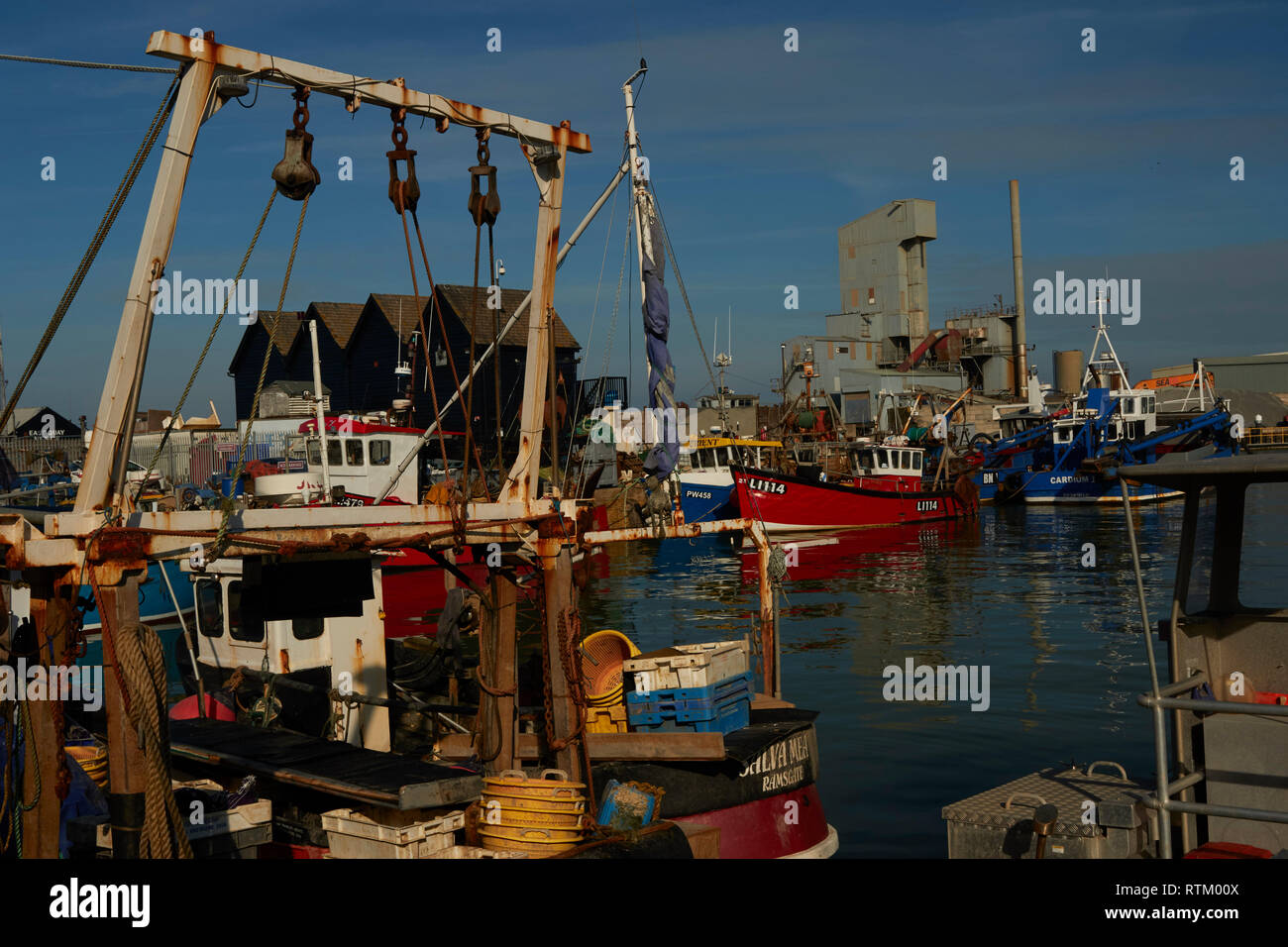 Colourful fishing boats moored in Whitstable harbour Kent coast