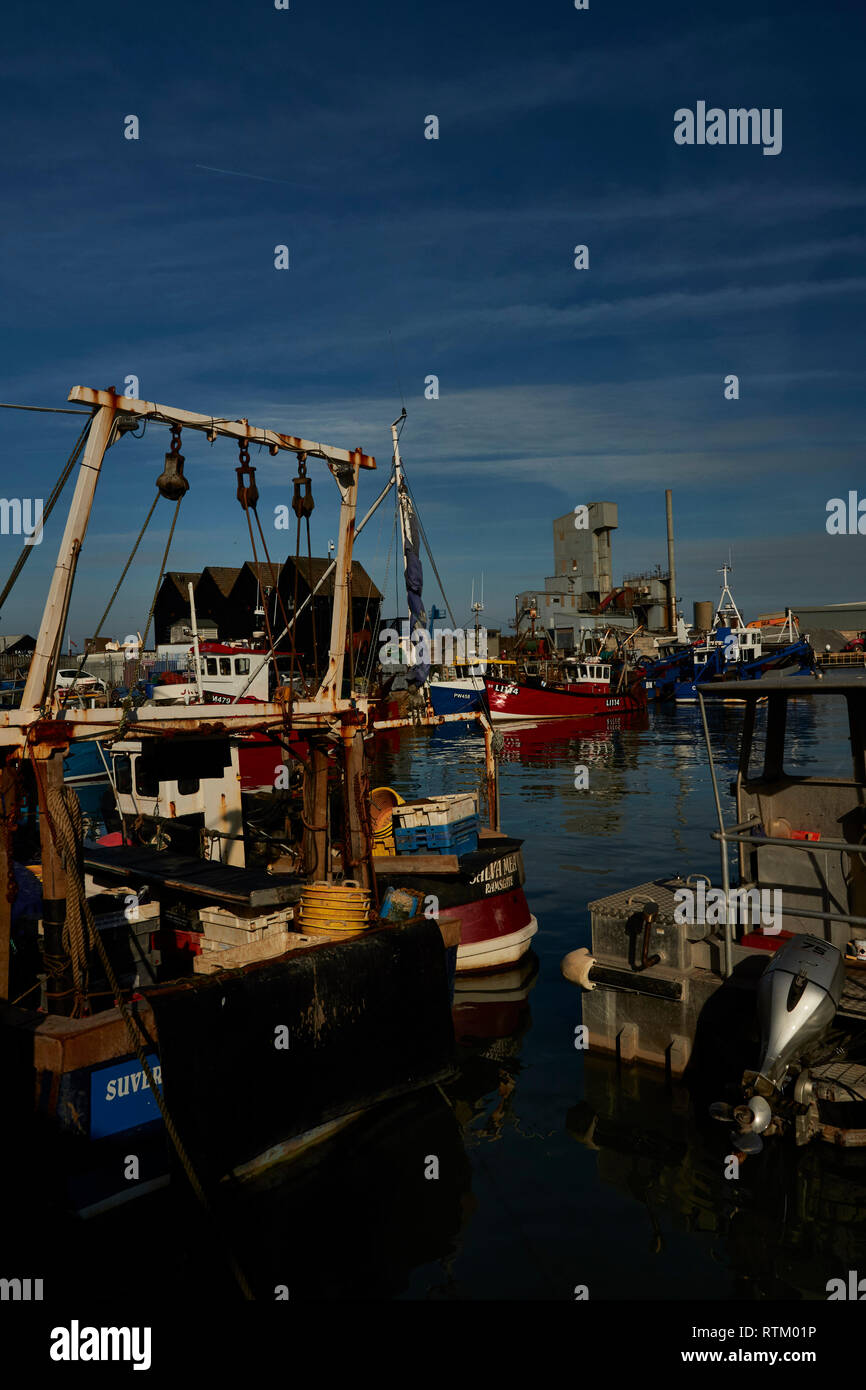 Colourful fishing boats moored in Whitstable harbour Kent coast