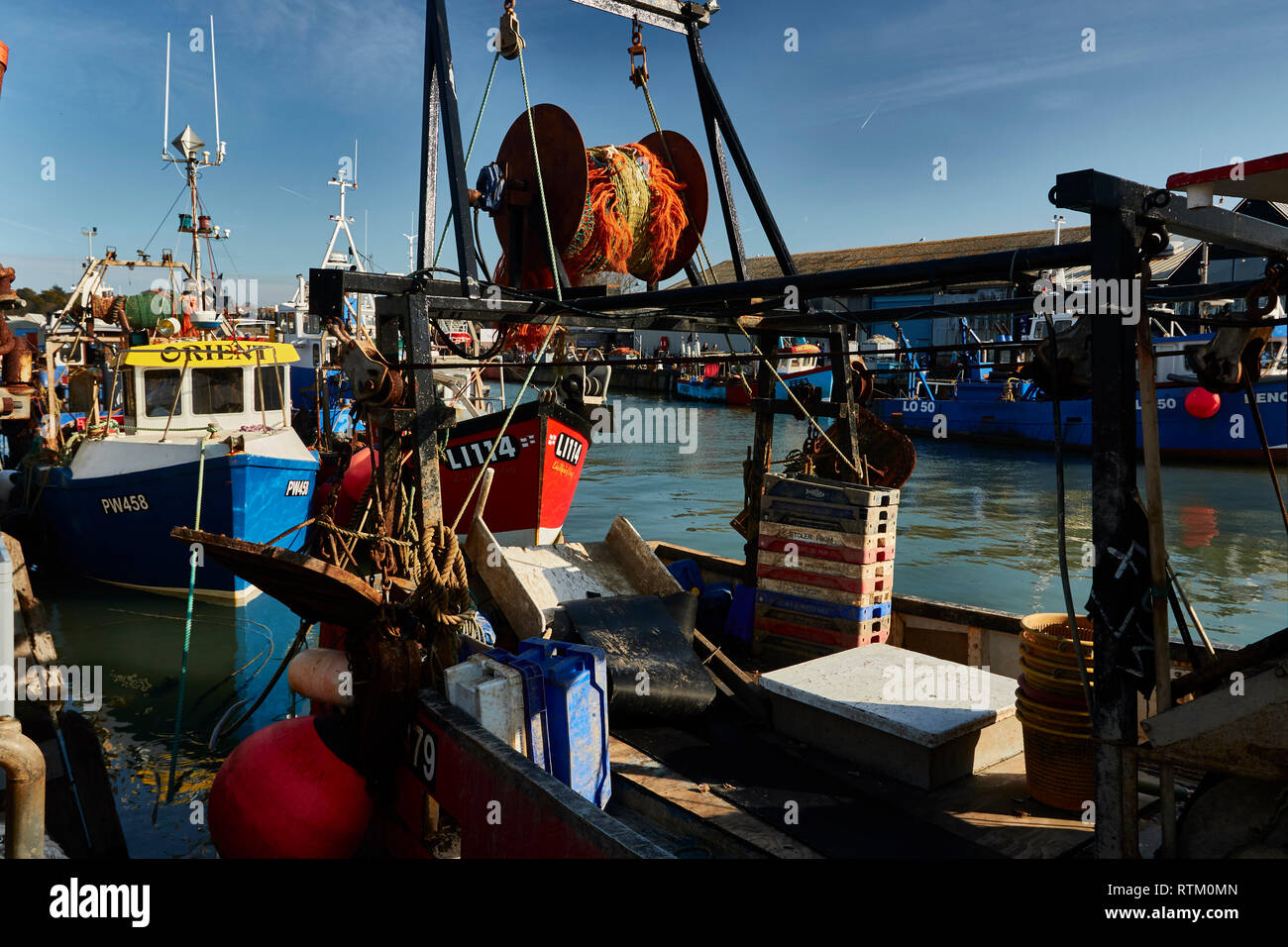 Colourful fishing boats moored in Whitstable harbour Kent coast