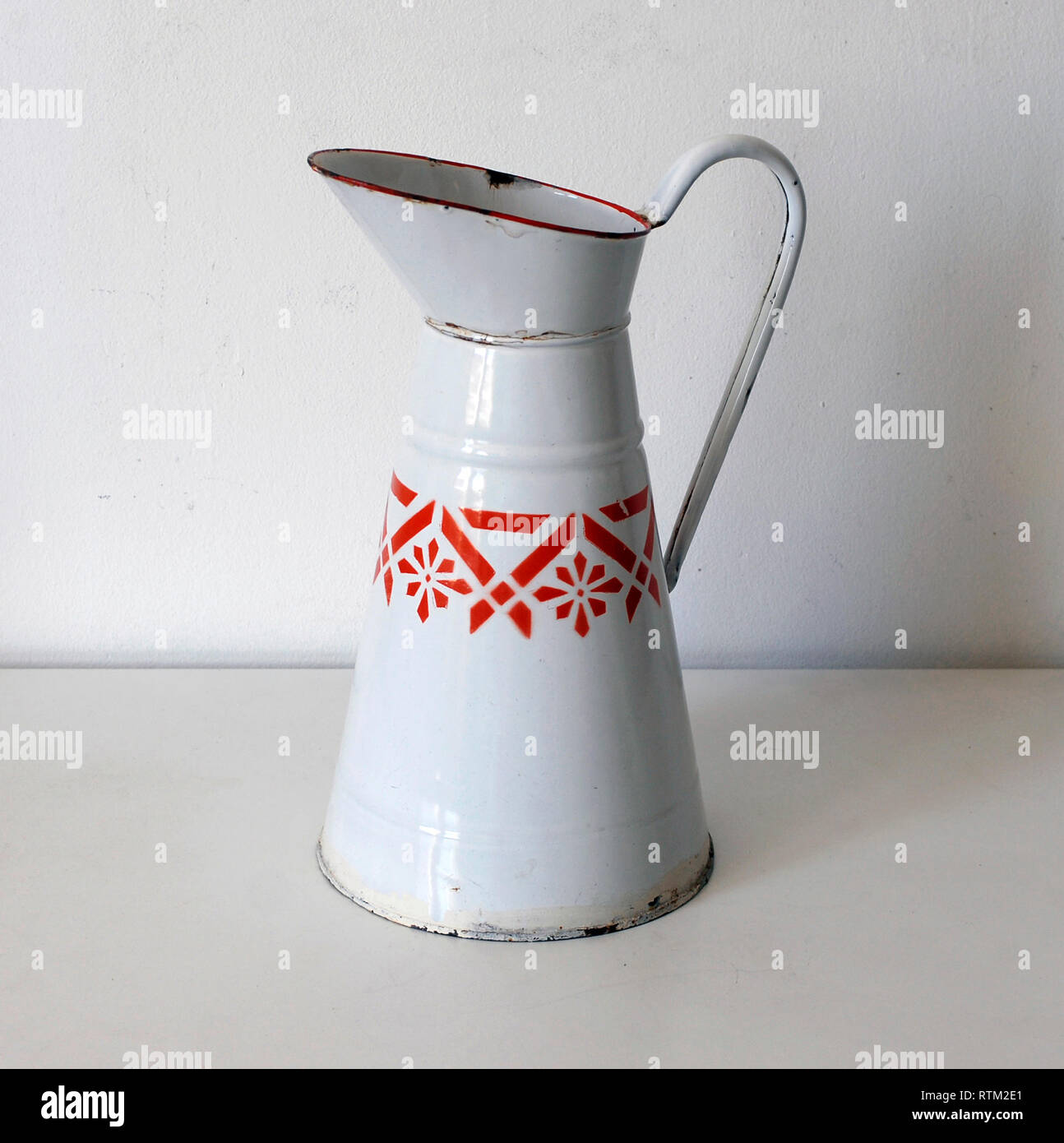 Vintage enameled metal jug, white and orange Stock Photo