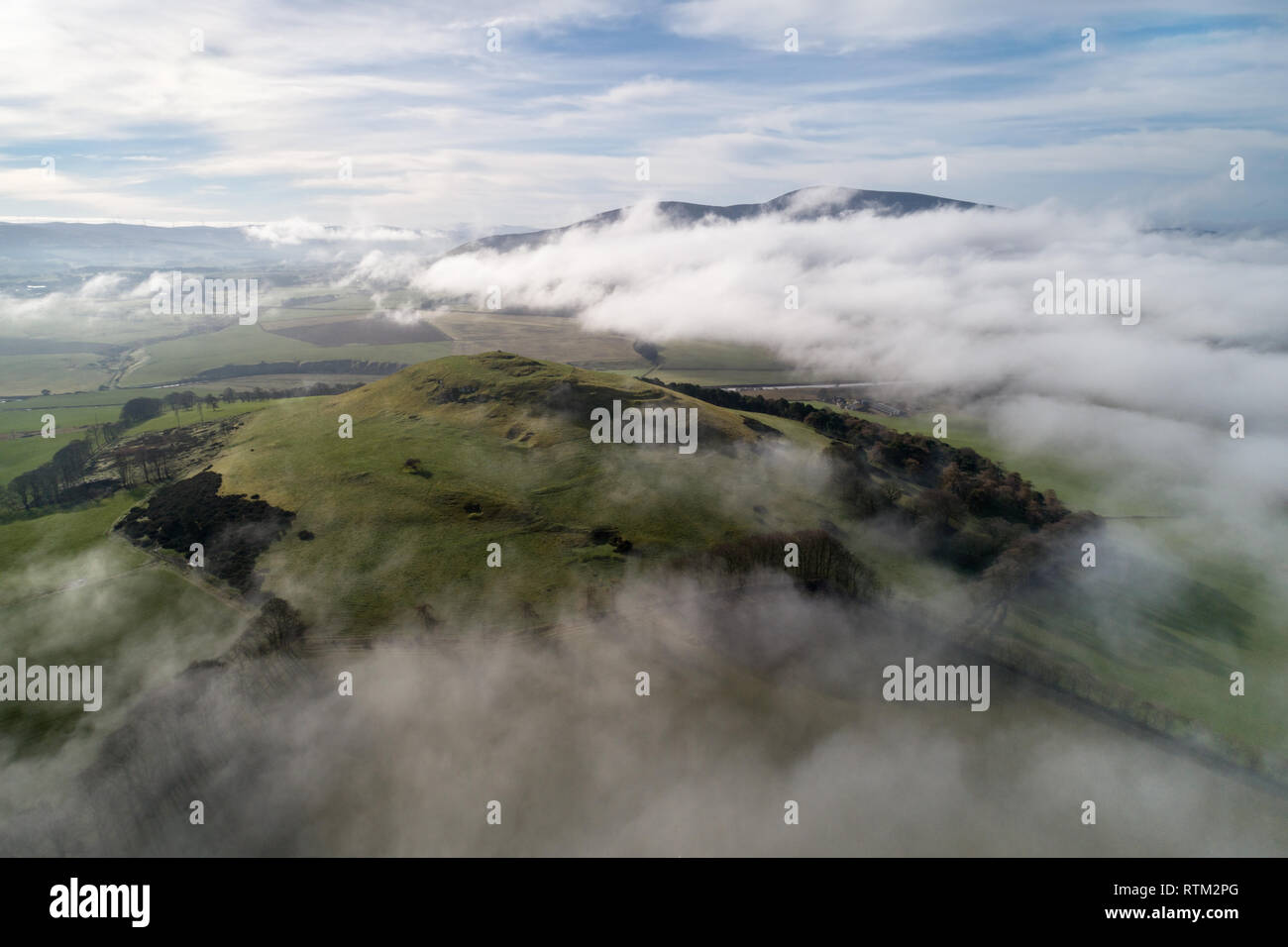 A cloud inversion over the Upper Clyde Valley in South Lanarkshire clearing to reveal Tinto Hill and Quathquan Law protruding above the mist. Stock Photo