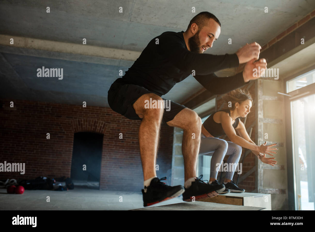 Caucasian determined sportsman performing plyometric box jumps indoor ...