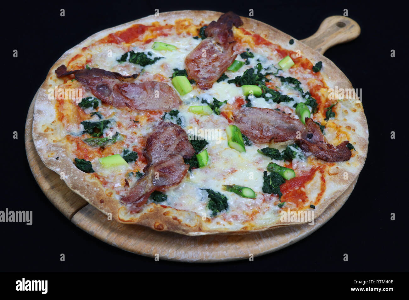 Thin crust Florentine pizza with bacon and spinach Stock Photo Alamy