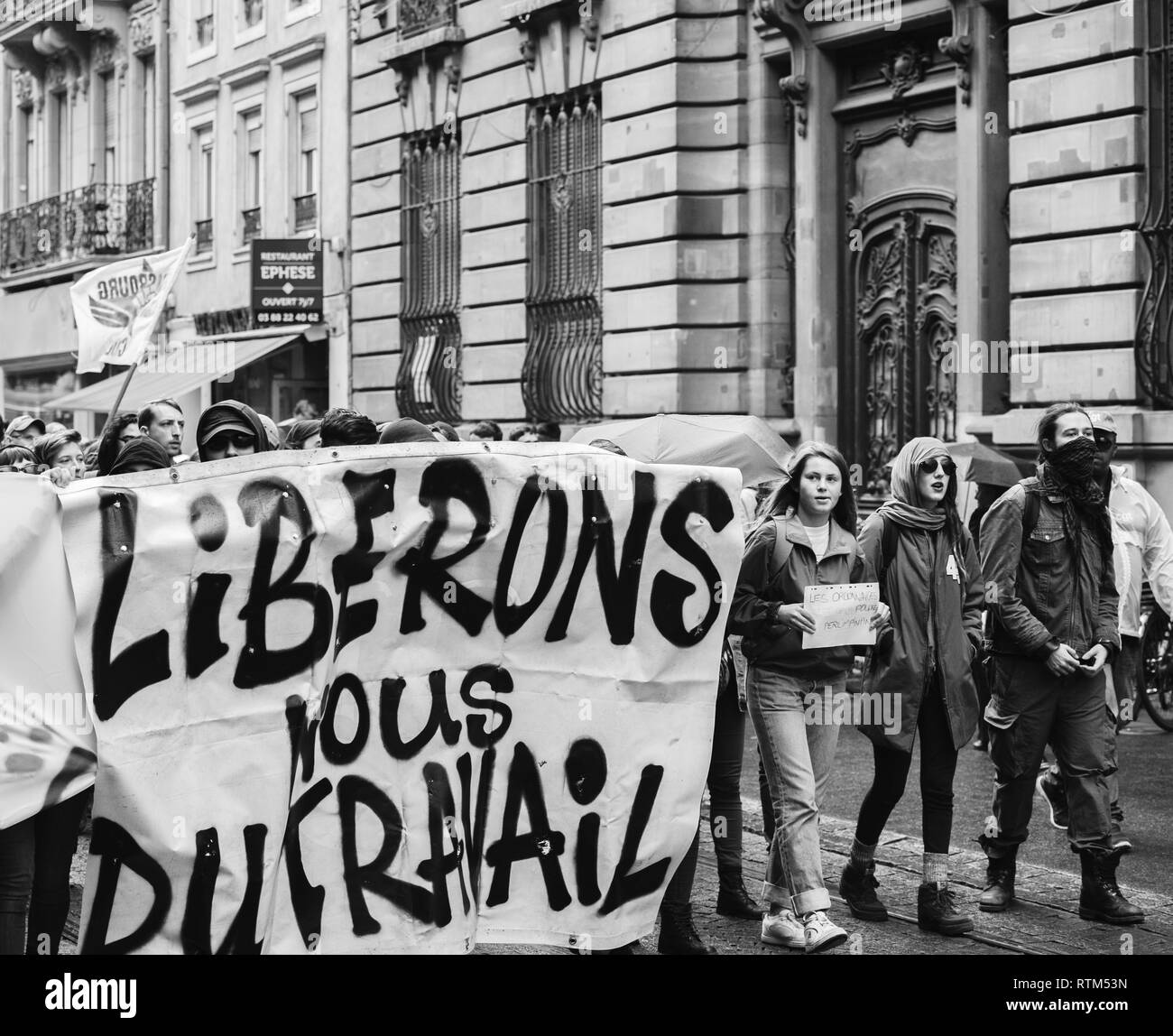 STRASBOURG, FRANCE - SEPT 12, 2017: Masked people with Soyons Revolutionnaires translated as Be Revolutionary poster at French Nationwide day of protest against the labor reform proposed by Emmanuel Macron Government Stock Photo
