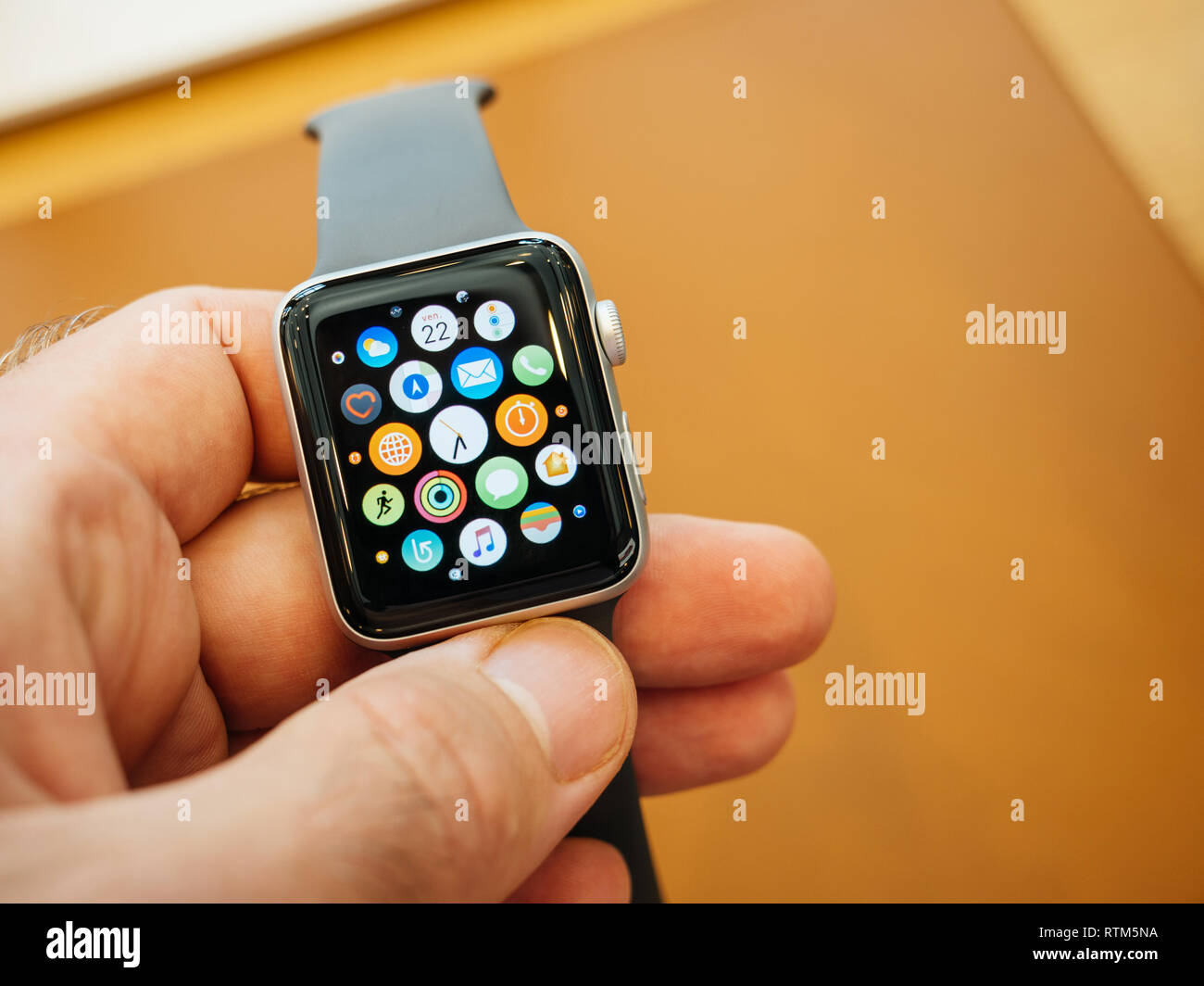 PARIS, FRANCE - SEP 22, 2017: New Apple Watch Series 3 goes on sale in Apple Store with male customer holding the face watch with home screen all apps  Stock Photo