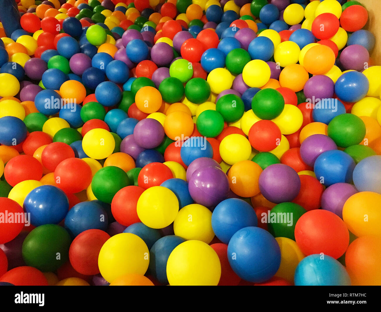 Colored plastic balls in pool of game room. Swimming pool for fun and jumping in colored plastic