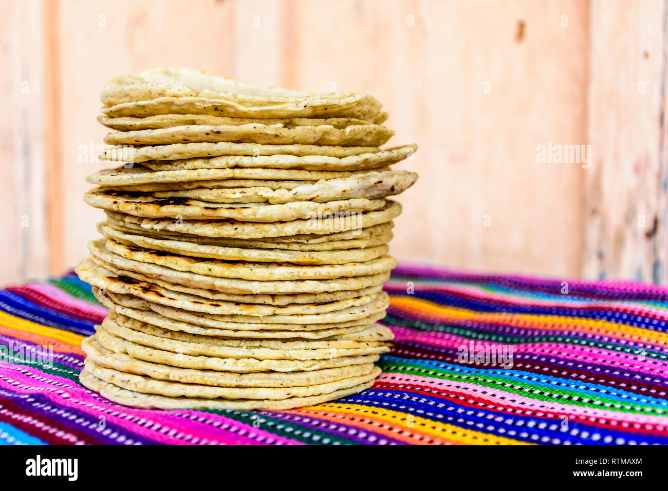 Stack of traditional handmade Guatemalan corn tortillas a staple food in Guatemala on colorful striped handwoven tablecloth Stock Photo