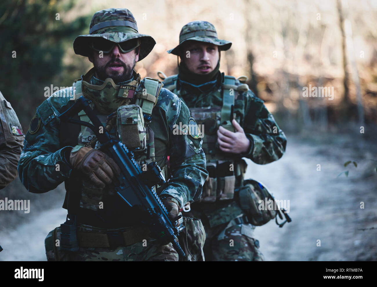 Airsoft military game players in camouflage uniform with armed assault rifle. Stock Photo