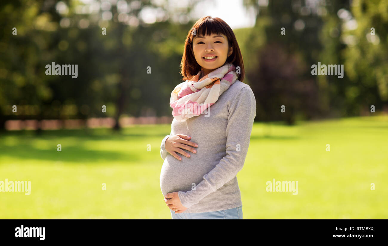 happy pregnant asian woman at park Stock Photo