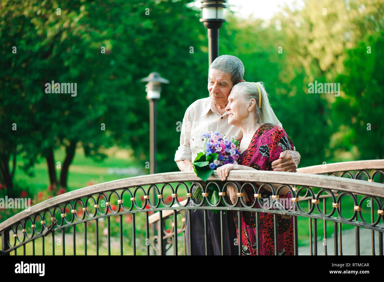 Age couple in love holding hands on a walk in the park in summer Stock ...