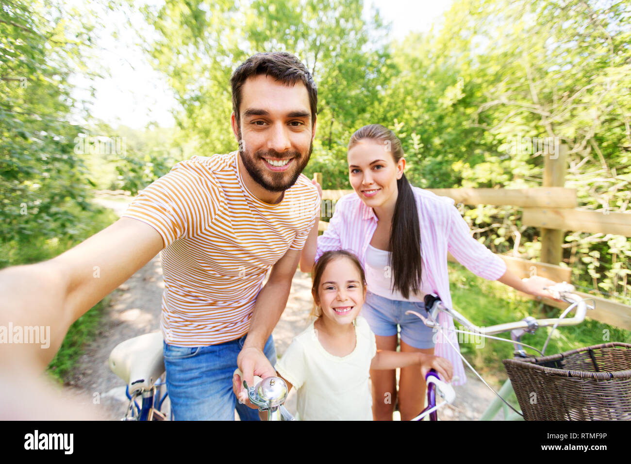 happy family with bicycles taking selfie in summer Stock Photo