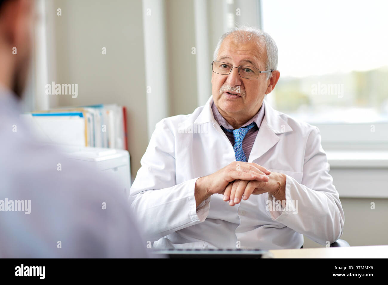 senior doctor talking to male patient at hospital Stock Photo - Alamy