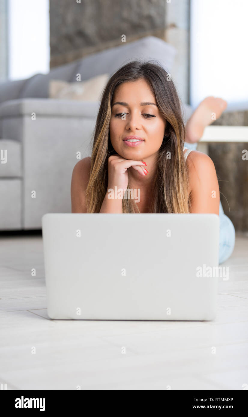 Beautiful young woman relaxing at home on her laptop computer Stock ...