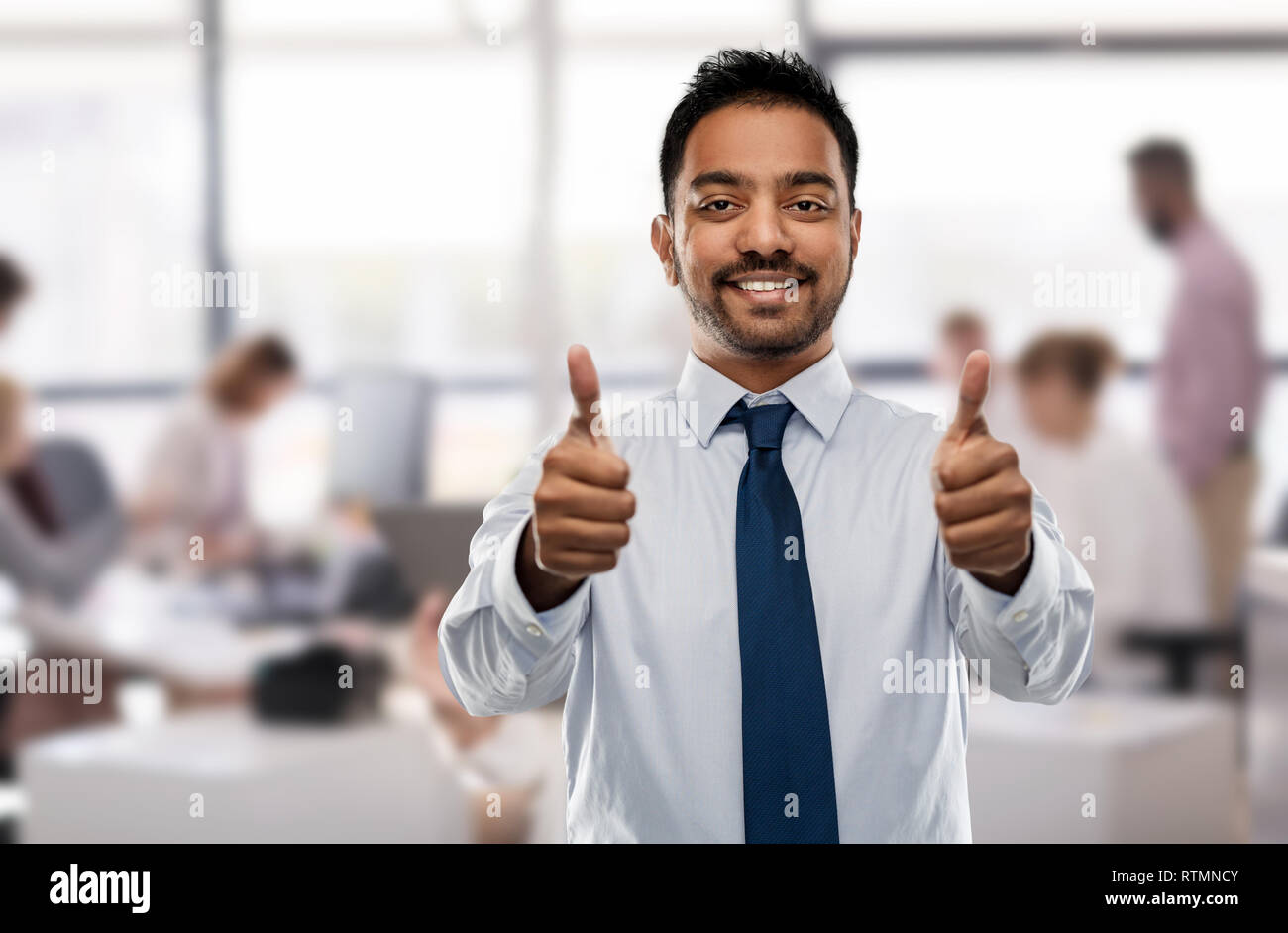 https://c8.alamy.com/comp/RTMNCY/indian-businessman-showing-thumbs-up-at-office-RTMNCY.jpg