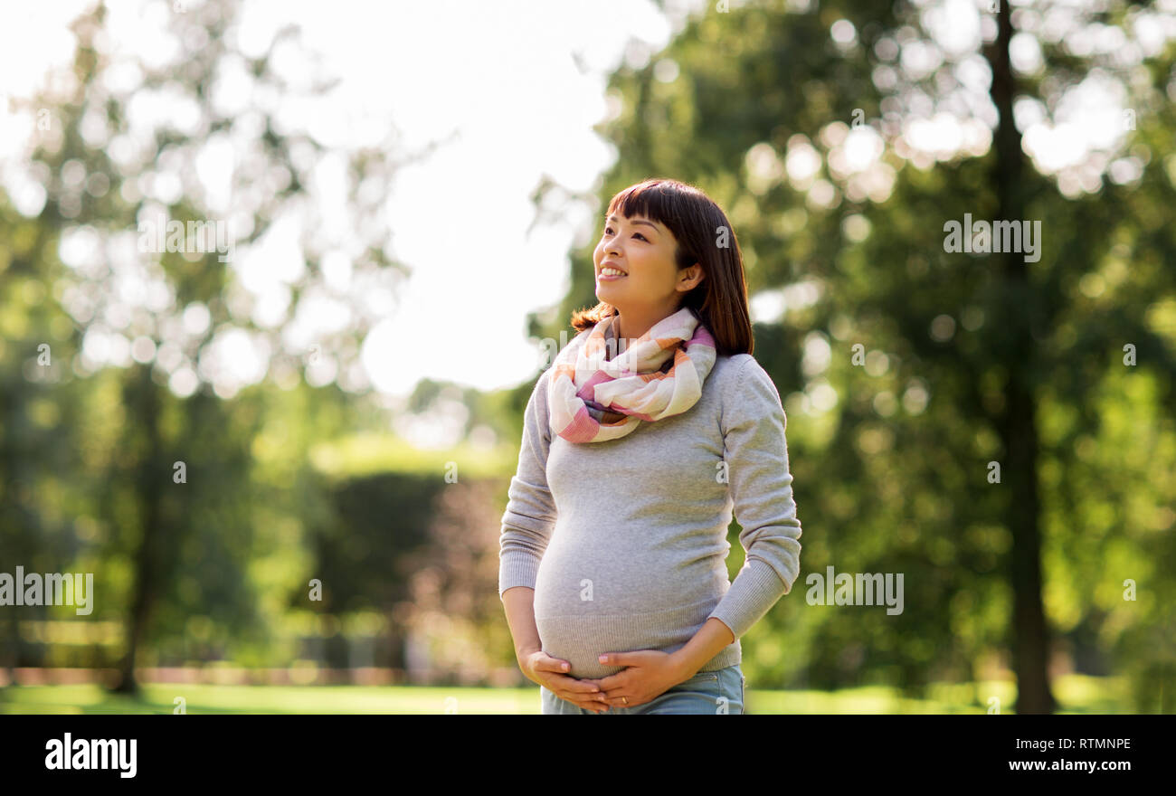 happy pregnant asian woman at park Stock Photo