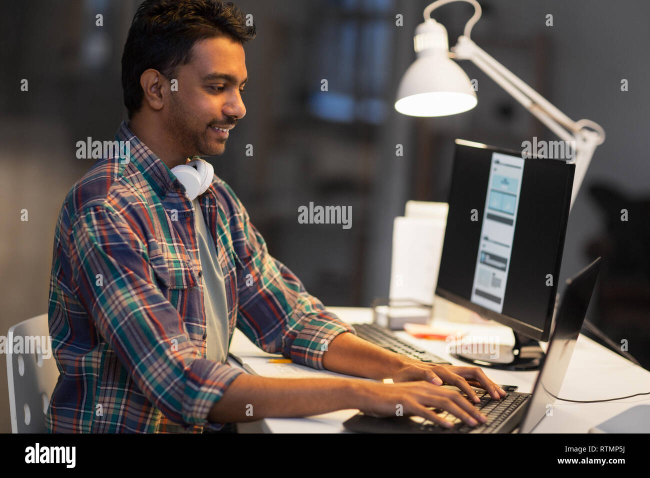 creative man with laptop working at night office Stock Photo - Alamy