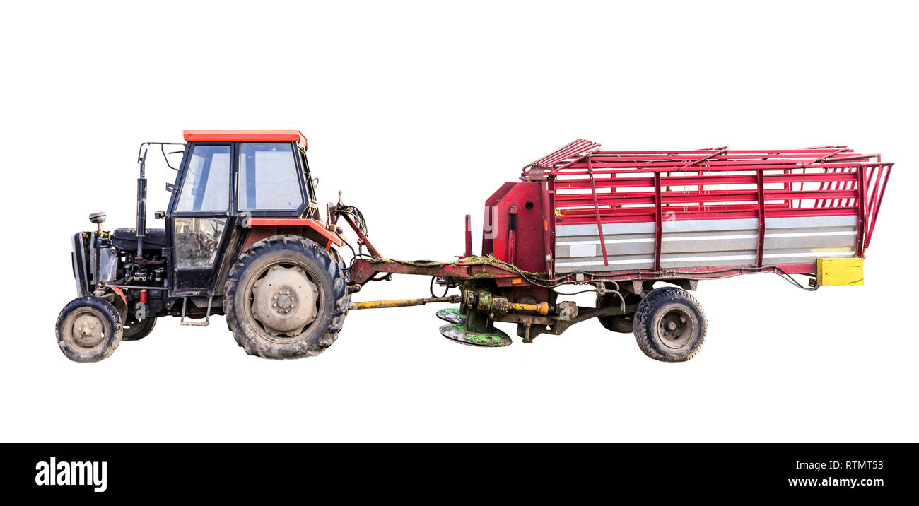 Tractor with a  trailer. The trailer is a rotary mower for various herbs and a container for mowed plants. Isolated photo.Equipment for a dairy farm. Stock Photo