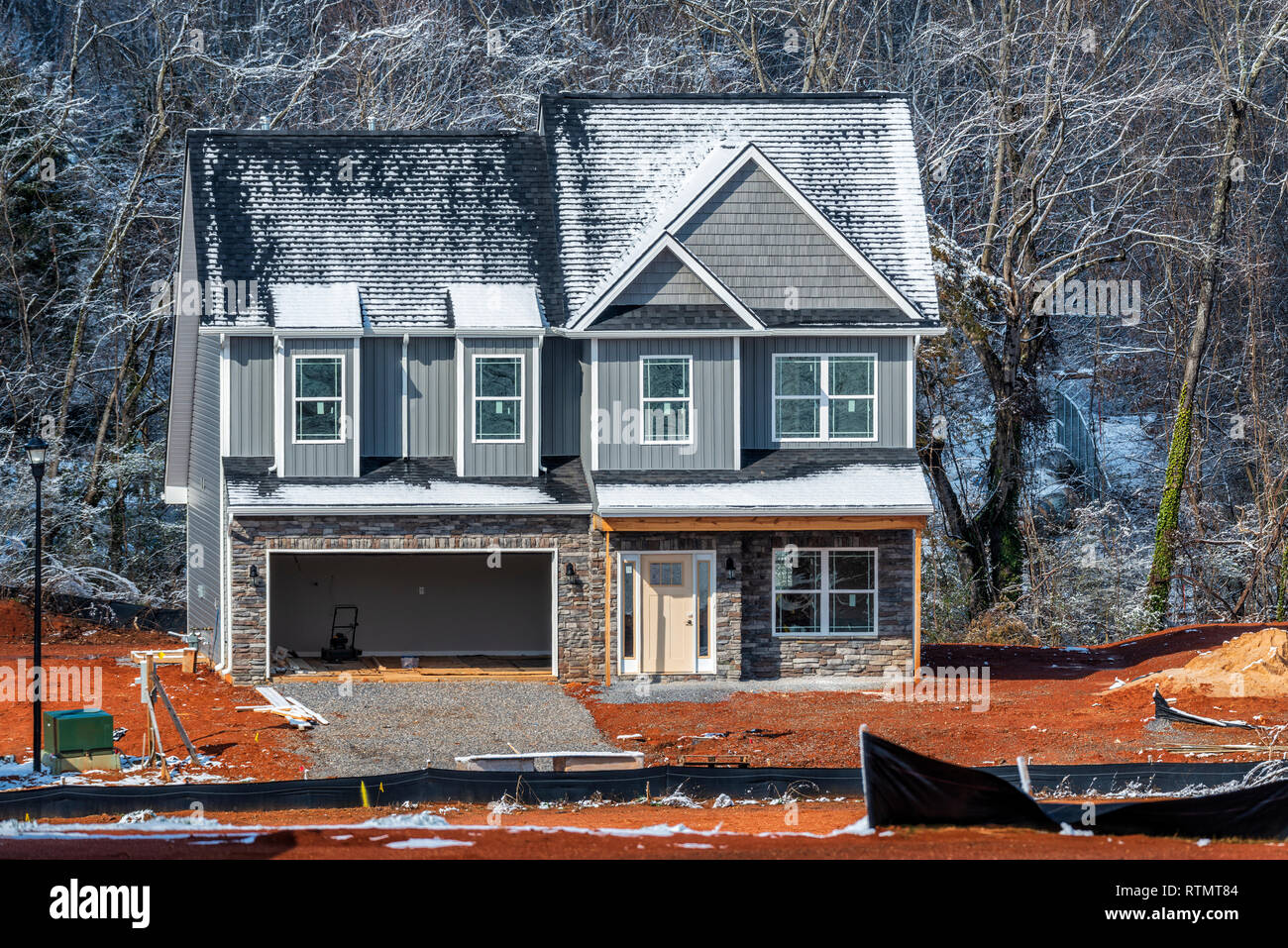 Horizontal shot of the front of a new two-story home construction site in winter. Stock Photo