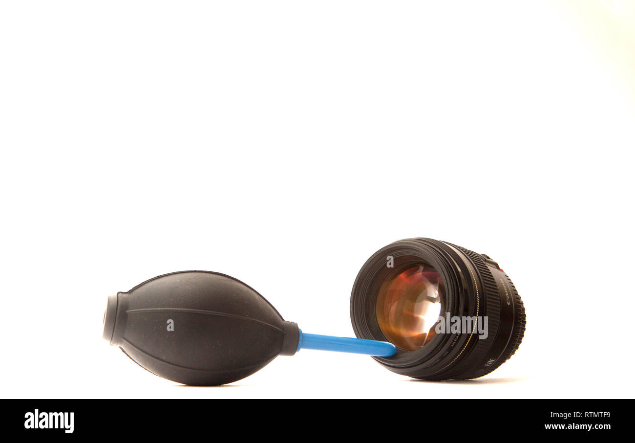 Technician engineer or photographer cleaning camera lens with air