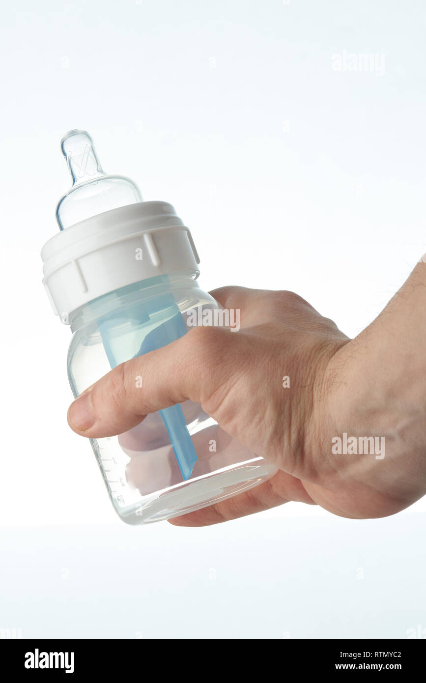 Hand holding plastic baby feeding bottle isolated on white background Stock Photo
