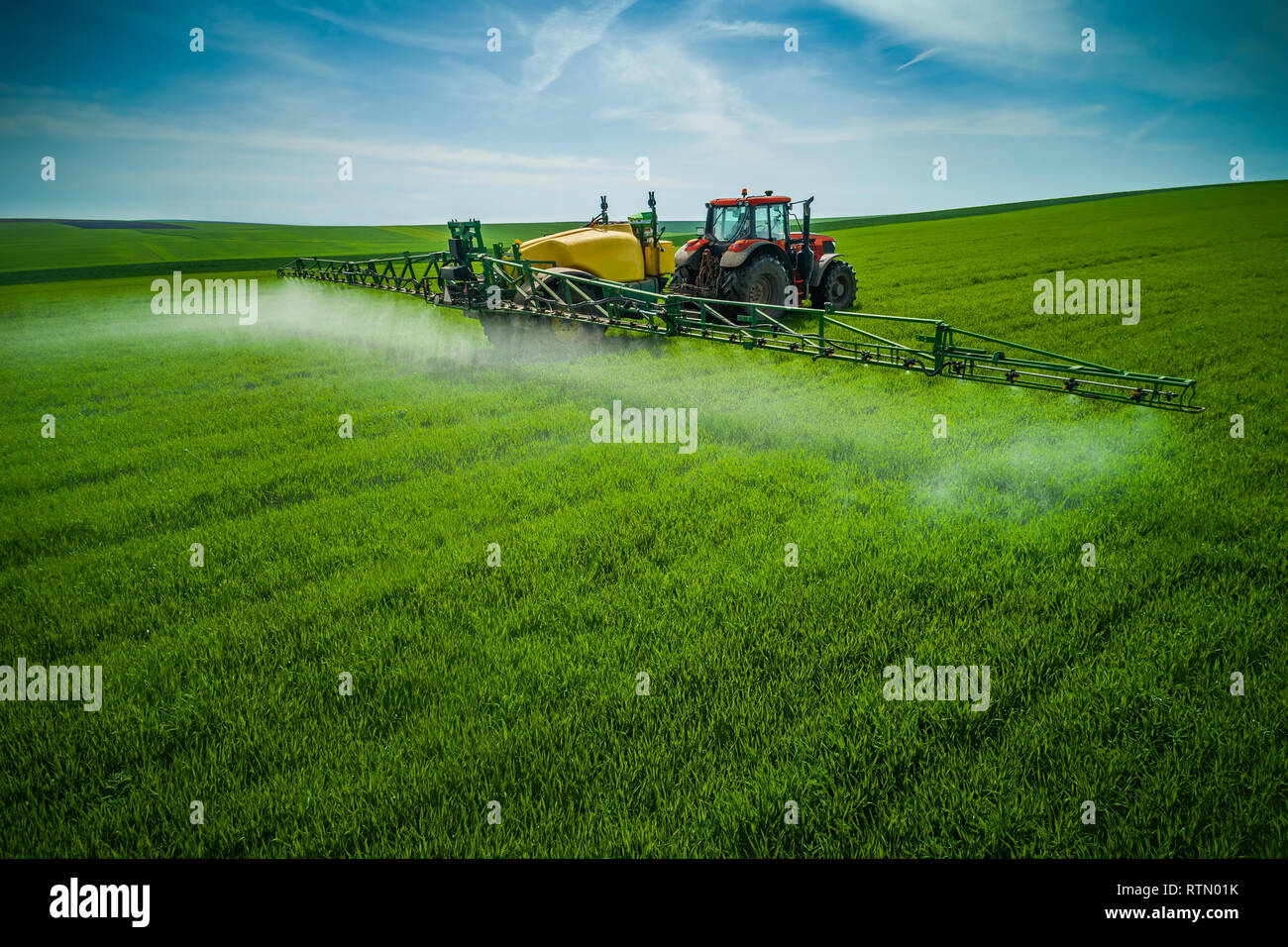 Aerial view of farming tractor plowing and spraying on field Stock ...
