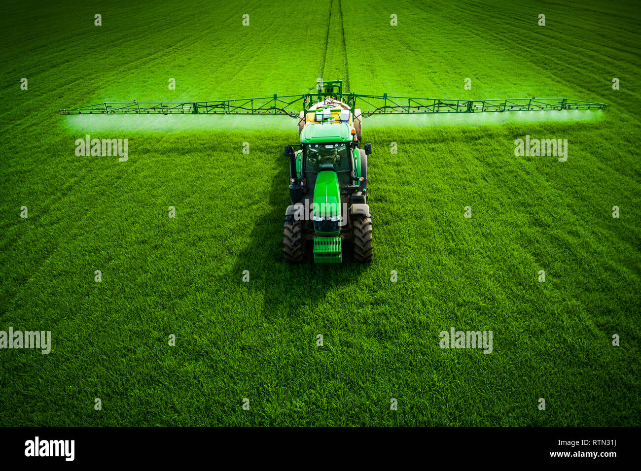 Aerial view of farming tractor plowing and spraying green field Stock ...