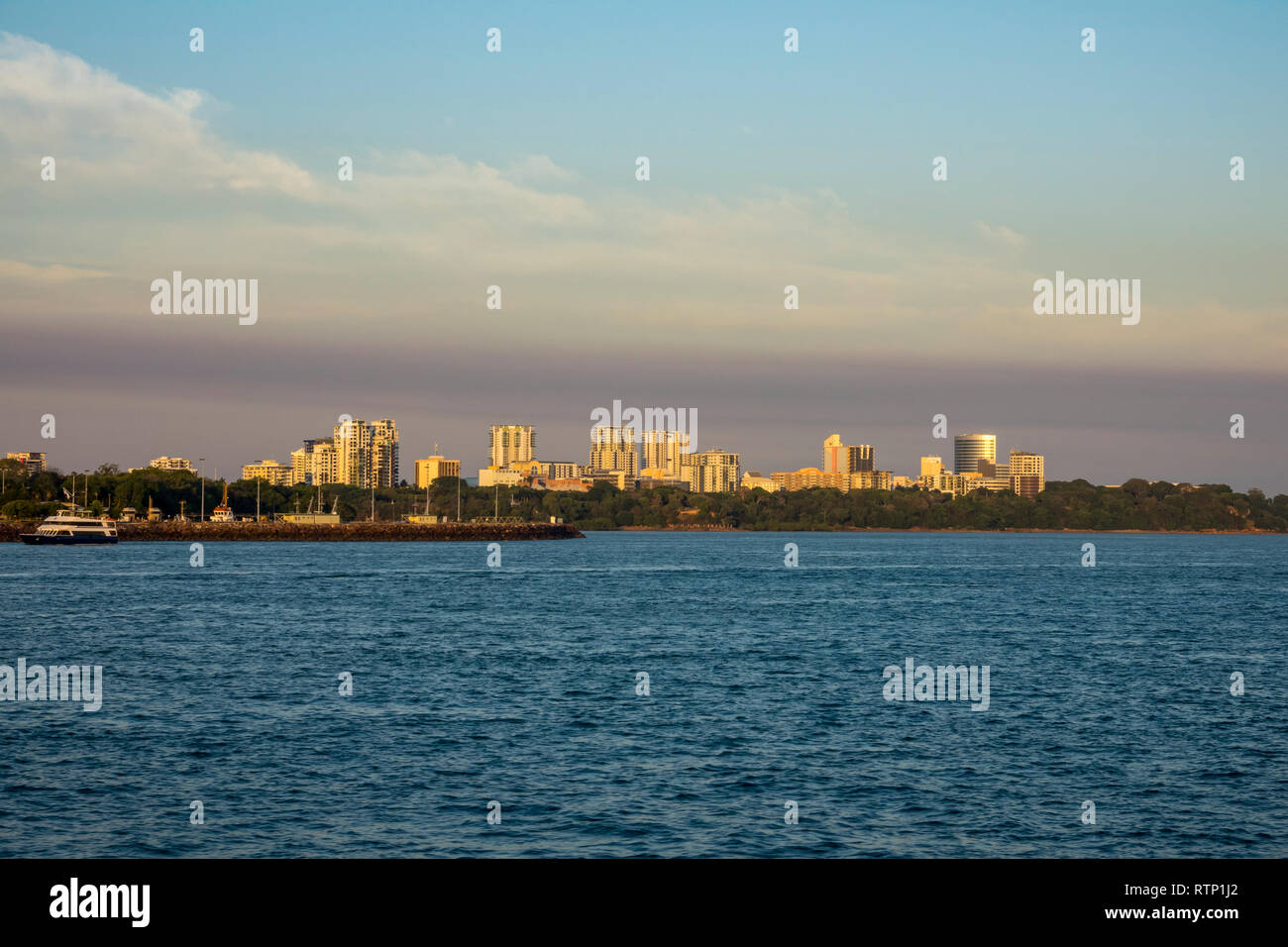 The city of Darwin at sundown, as seen from ship departing Darwin Port, Northern Territory, Australia Stock Photo