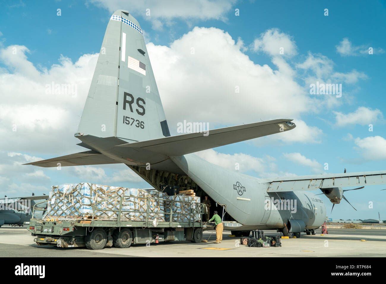 U.S. air operation contractors load a C-130J Hercules, assigned to the 75th Expeditionary Airlift Squadron (EAS), with pallets of water at Camp Lemonnier, Djibouti, Jan. 12, 2019. The 75th EAS supports Combined Joint Task Force – Horn of Africa with medical evacuations, disaster relief, humanitarian and airdrop operations. (U.S. Air Force photo by Tech. Sgt. Thomas Grimes) Stock Photo