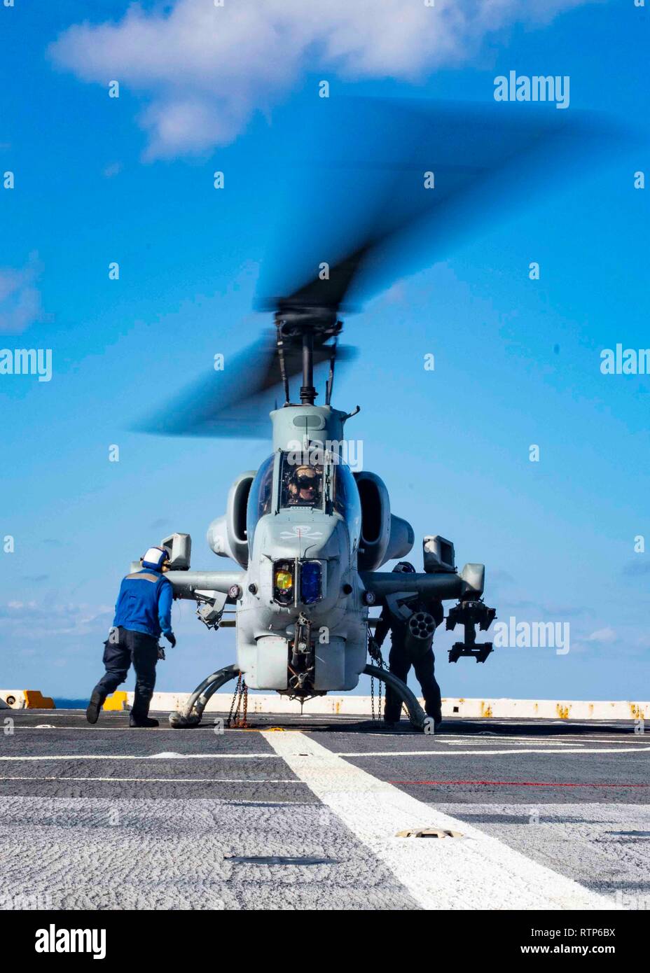 190226-N-HG389-0012 MEDITERRANEAN SEA (Feb. 26, 2019) Sailors remove chains on an AH-1W Super Cobra helicopter assigned to the “Black Knights” of Marine Medium Tiltrotor Squadron (VMM) 264 (Reinforced) on the flight deck of the San Antonio-class amphibious transport dock ship USS Arlington (LPD 24), Feb. 26, 2019. Arlington is on a scheduled deployment as part of the Kearsarge Amphibious Ready Group in support of maritime security operations, crisis response and theater security cooperation, while also providing a forward naval presence. (U.S. Navy photo by Mass Communication Specialist 2nd Cl Stock Photo