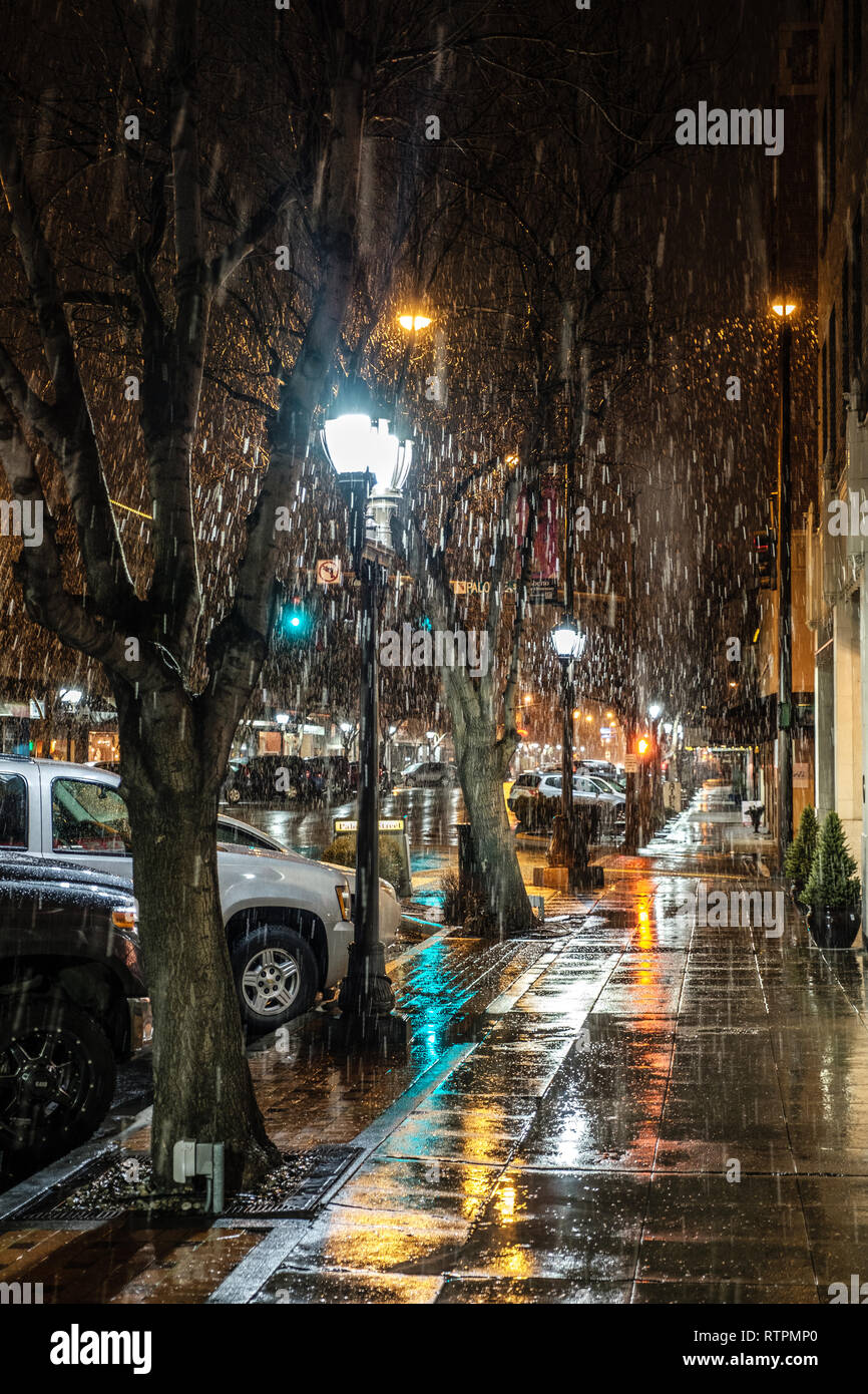 Snow falls on a well-lit downtown as the photographer waits for his Vietnamese takeout.  Quality restaurants abound in a bussling agricultural community, Stock Photo