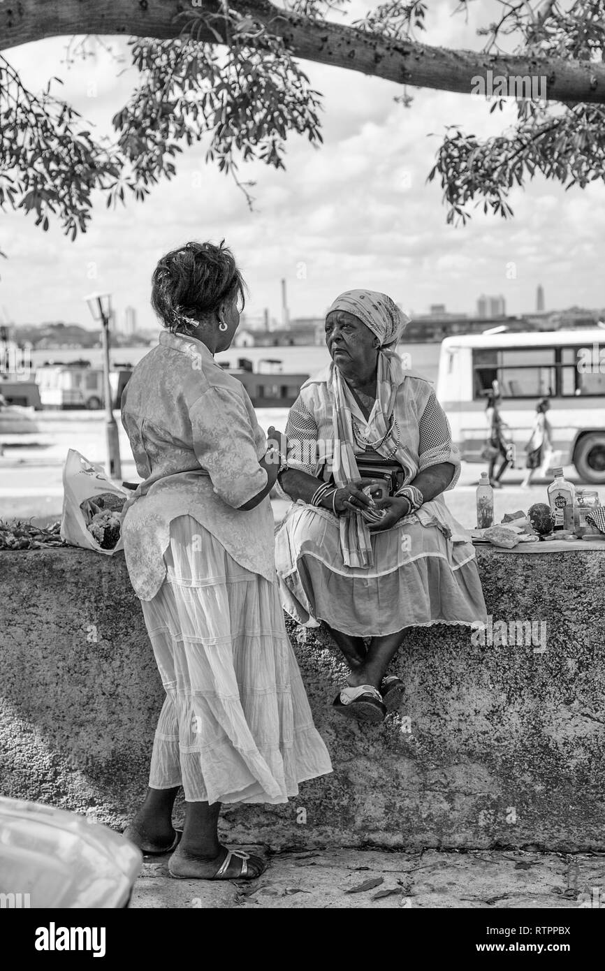 Havana, Cuba - 12 January 2013: A view of the streets of the city with cuban people. A woman is consulting the voodoo, vodun woman. Stock Photo