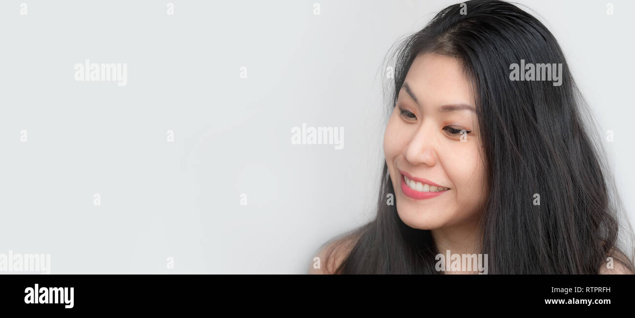 Headshot of Relaxed confident happy Asian Thai Chinese woman smiling with black hair, makeup, happy fresh on white background looking Stock Photo