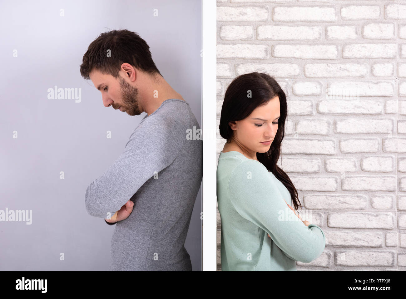 Side View Of Young Unhappy Couple Standing Back To Back At Home Stock Photo