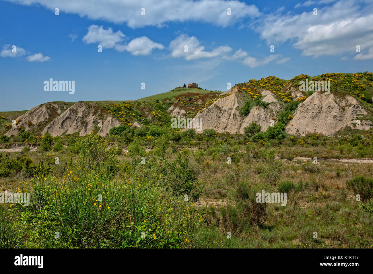 View of the Crete Senesi country landscape with a old ruin. Crete Senesi landscape erosion forms of Calanchi near Siena, Tuscany, Italy Stock Photo