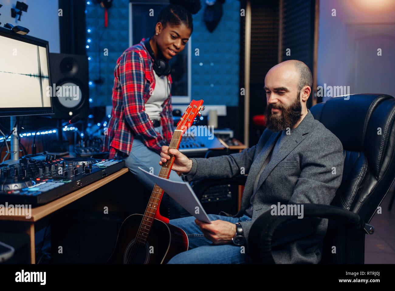 Male and female musicians in sound recording studio. Performers on